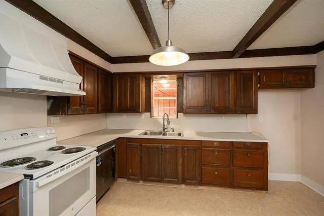a kitchen with a sink a stove and cabinets