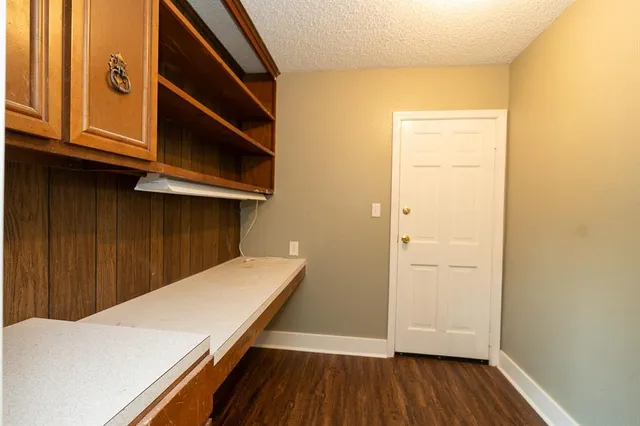 an empty room with windows and chandelier fan