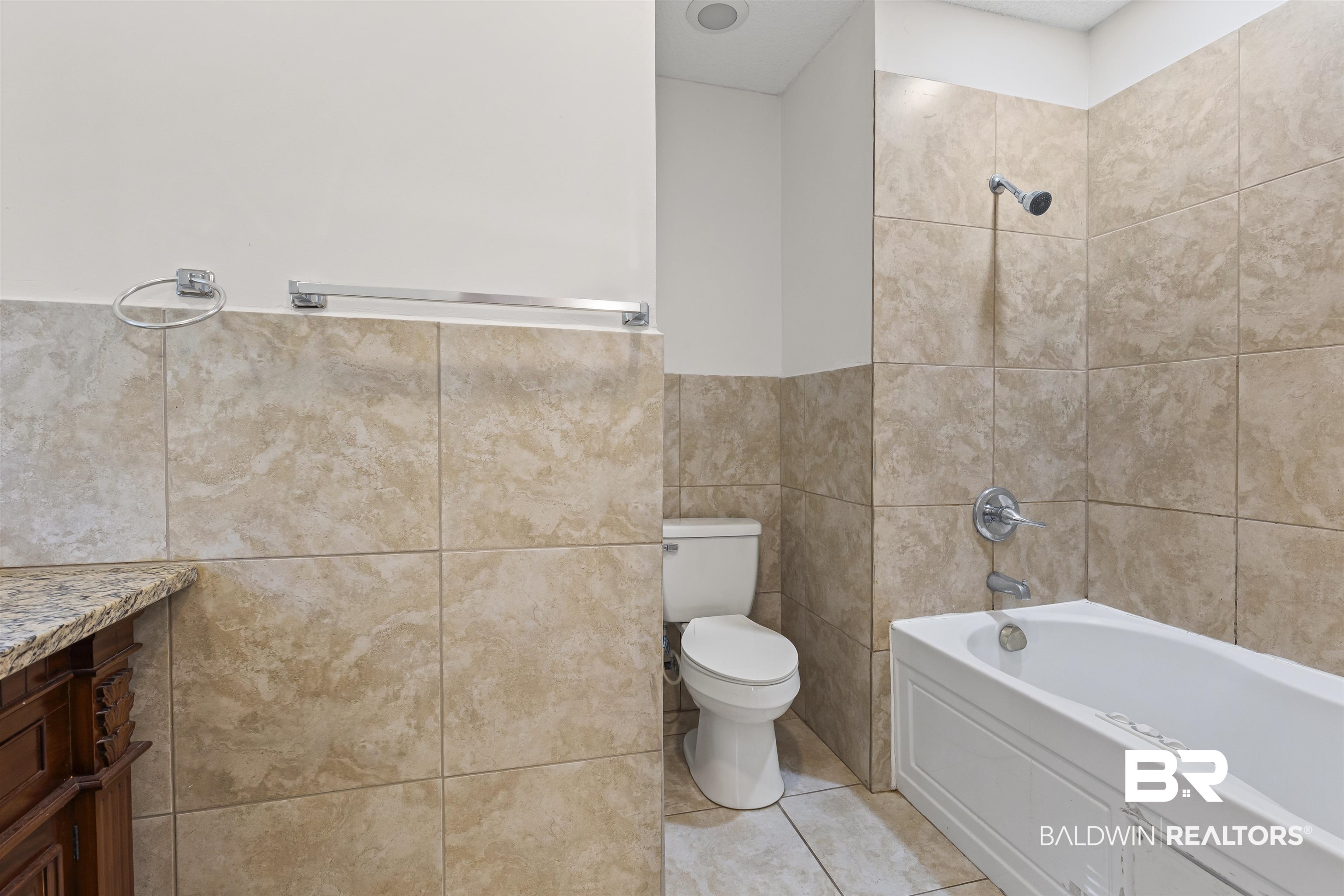 1108 Locarno Street Mobile, AL 36608 - Photo 19 of 24 Bathroom with tile patterned floors, tile walls, vanity, and shower / washtub combination