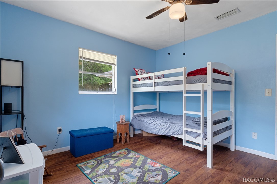 3355 South Highlands Avenue Inverness, FL 34452 - Photo 22 of 30 a bedroom with bunk bed and a chandelier