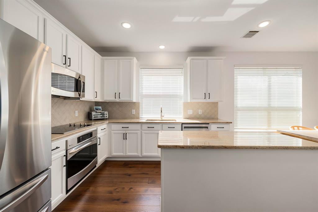 2524 Windgate Drive Frisco, TX 75033 - Photo 8 of 38 a kitchen with granite countertop white cabinets and white stainless steel appliances