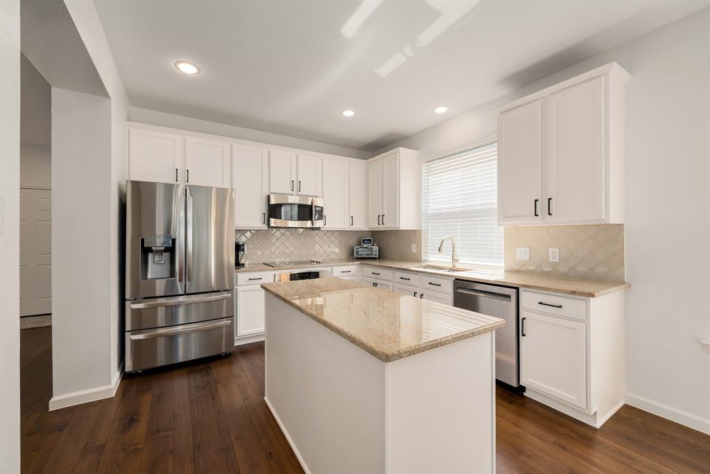2524 Windgate Drive Frisco, TX 75033 - Photo 9 of 38 a kitchen with a refrigerator a sink and wooden floor