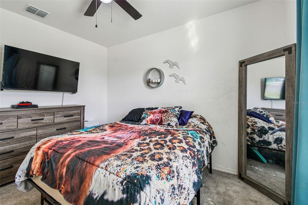 8207 Abalone Loop Palmetto, FL 34221 - Photo 16 of 37 a bedroom with a bed and a flat screen tv