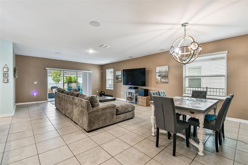 8207 Abalone Loop Palmetto, FL 34221 - Photo 25 of 37 a living room with furniture a chandelier and a flat screen tv