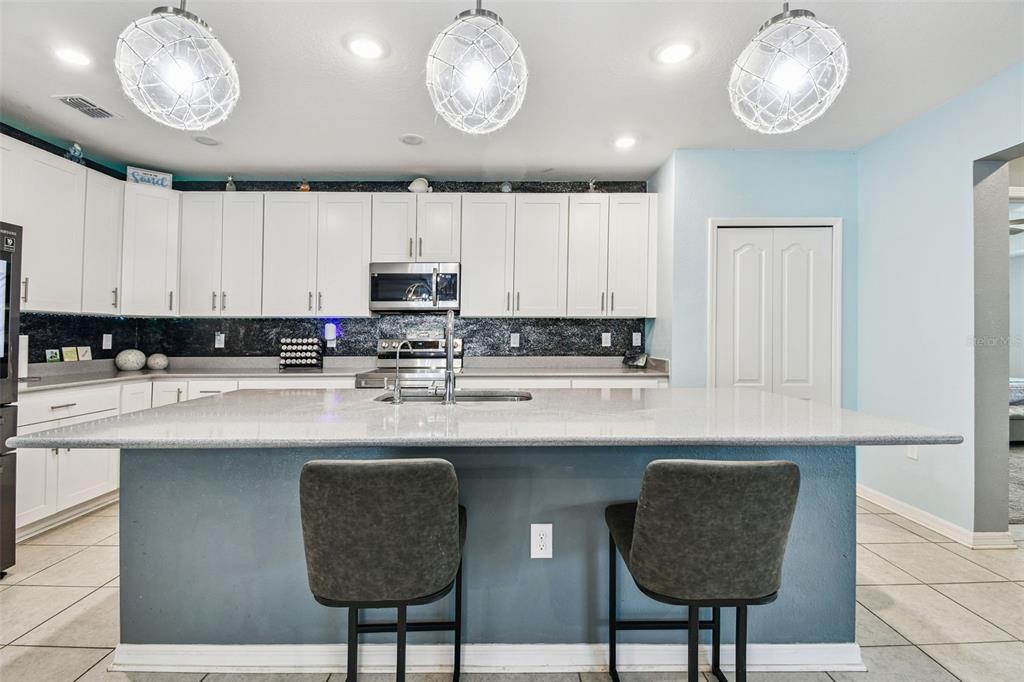 8207 Abalone Loop Palmetto, FL 34221 - Photo 4 of 37 a kitchen with stainless steel appliances granite countertop a sink a stove and a microwave