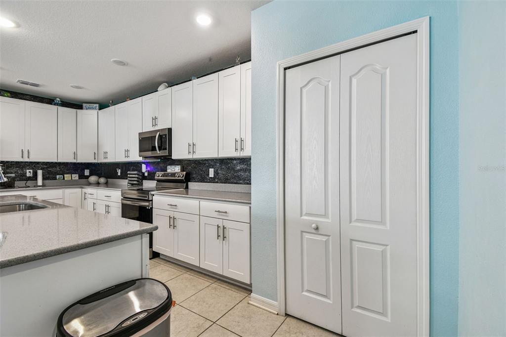 8207 Abalone Loop Palmetto, FL 34221 - Photo 6 of 37 a kitchen with white cabinets and white appliances