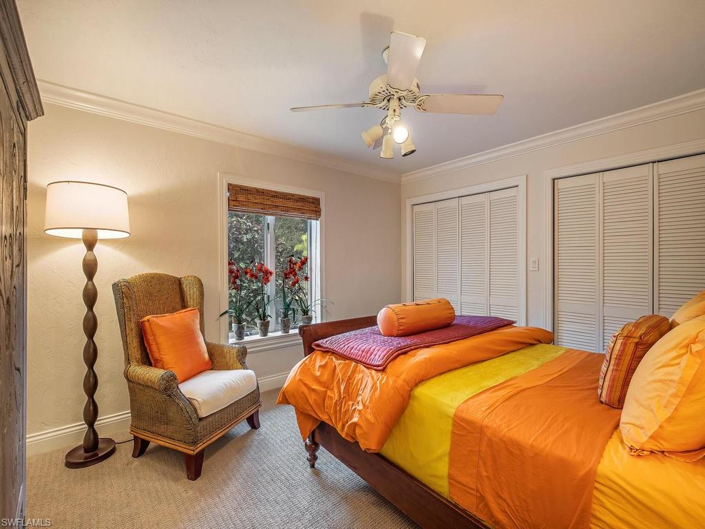 1673 Mandarin Road Naples, FL 34102 - Photo 12 of 16 a bedroom with bed and lamp with window