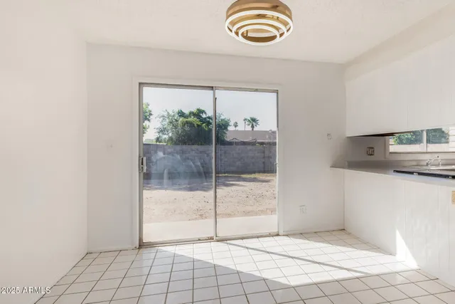 a view of an empty room and kitchen view