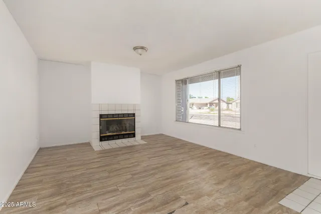 an empty room with windows and fireplace