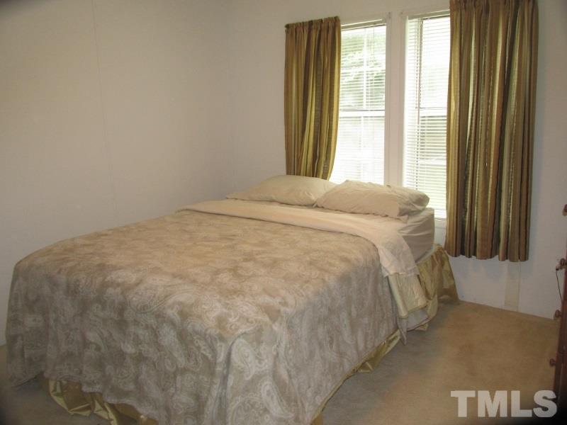 1509 Riverview Road Raleigh, NC 27610 - Photo 14 of 25 a large bed sitting in a bedroom next to a window