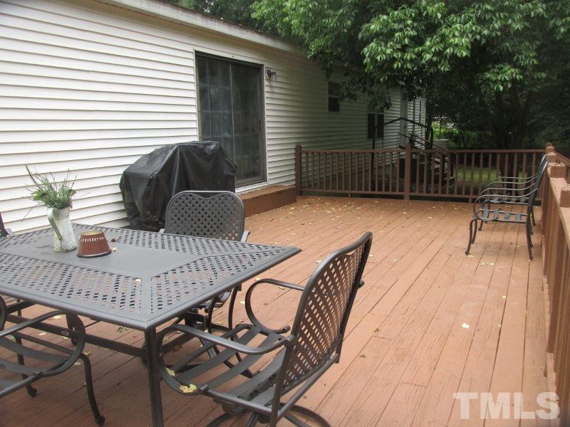 1509 Riverview Road Raleigh, NC 27610 - Photo 22 of 25 a view of a patio with table and chairs with wooden floor and fence