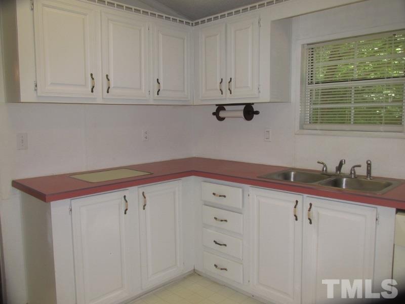1509 Riverview Road Raleigh, NC 27610 - Photo 8 of 25 a kitchen with granite countertop white cabinets and sink