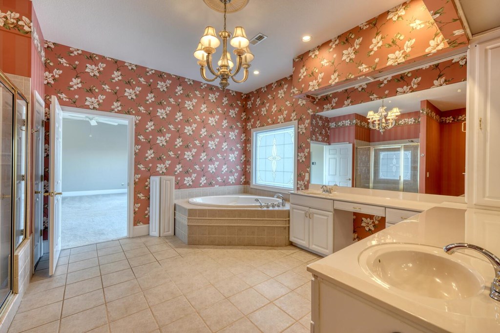 1436 Harris Ridge Road Young Harris, GA 30582 - Photo 37 of 86 a spacious bathroom with a granite countertop sink a large mirror and a bathtub with shower