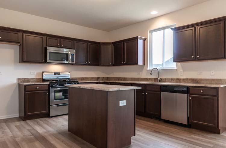 933 Willow Road Manteno, IL 60950 - Photo 2 of 20 a kitchen with granite countertop wooden cabinets and stainless steel appliances