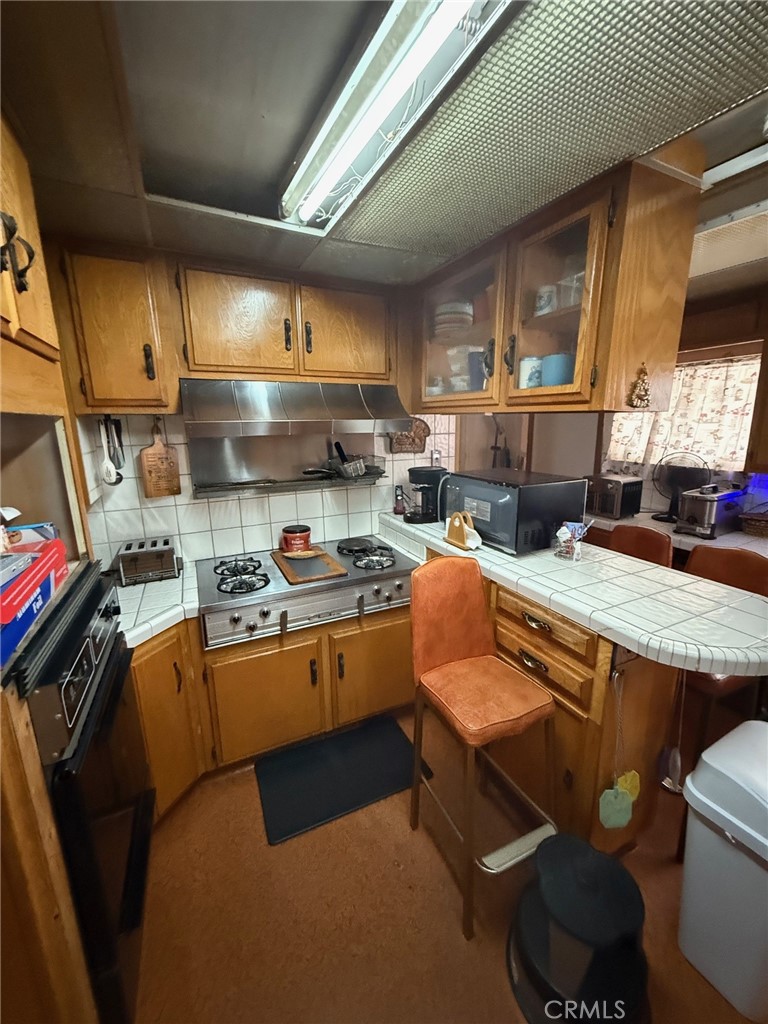471 West Bennett Street Compton, CA 90220 - Photo 9 of 20 a kitchen with stainless steel appliances granite countertop a stove a sink dishwasher and cabinets with wooden floor
