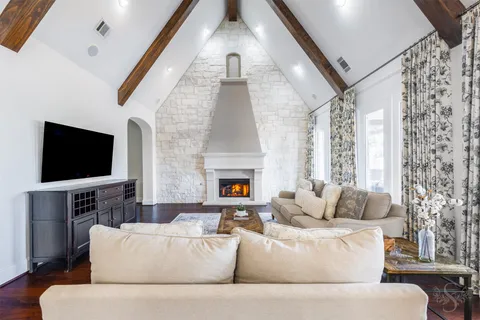 a living room with furniture a fireplace and a flat screen tv