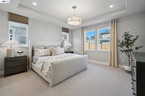 a spacious bedroom with a bed and a chandelier