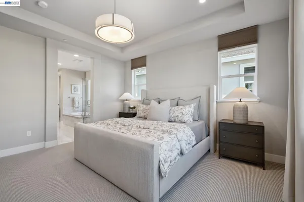 a spacious bedroom with a bed and a lamp