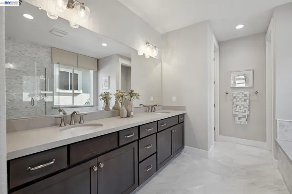a bathroom with a double vanity sink a mirror and a shower