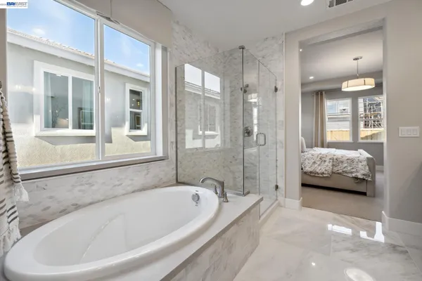 a en suite spacious bathroom with a tub shower and window