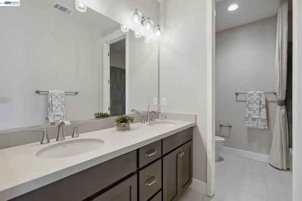 a bathroom with a double vanity sink mirror and shower