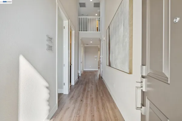 a view of a hallway with wooden floor and staircase