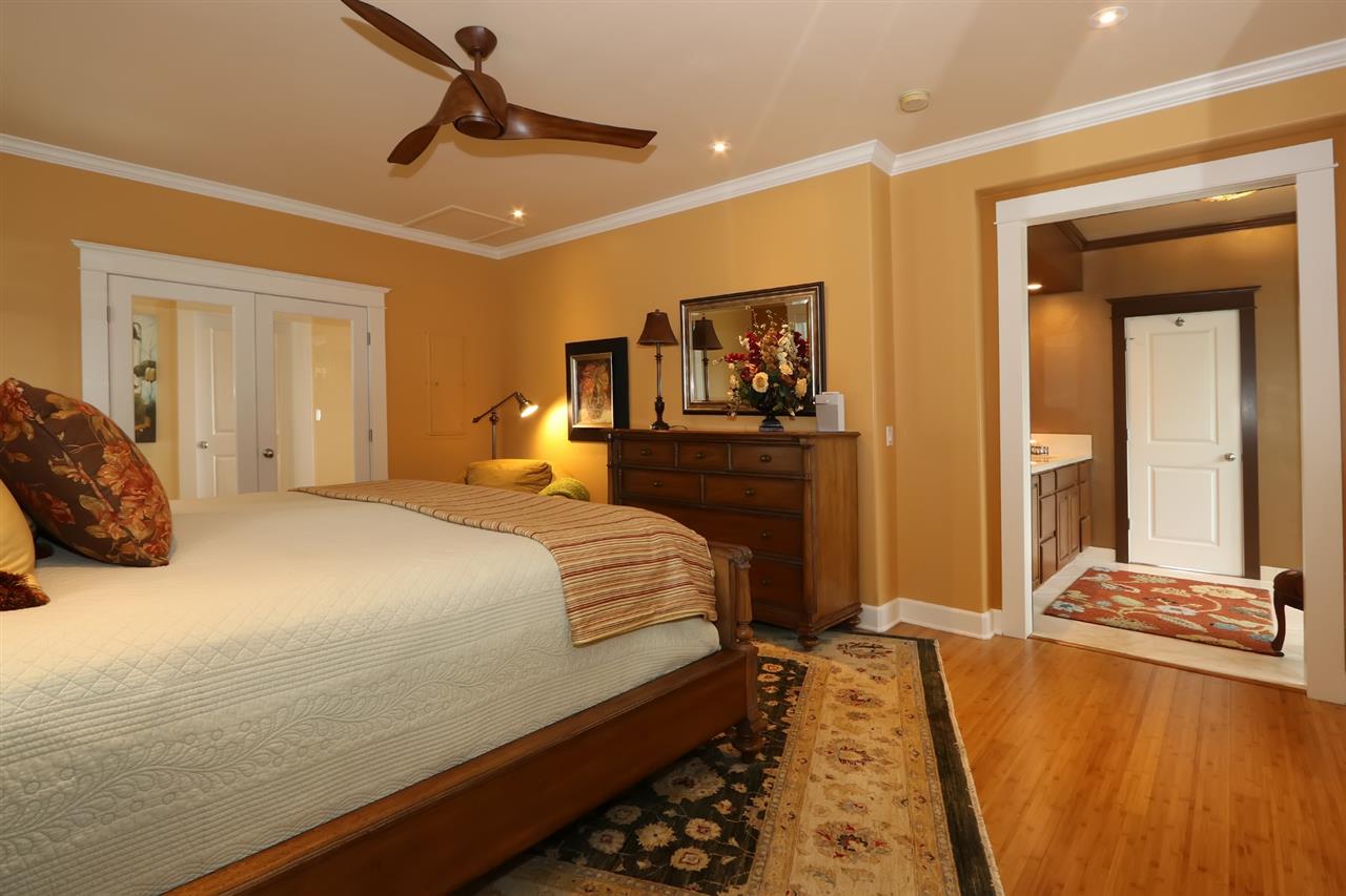 1268 Lower Kimo Drive Kula, HI 96790 - Photo 14 of 30 a bedroom with a bed and a chandelier