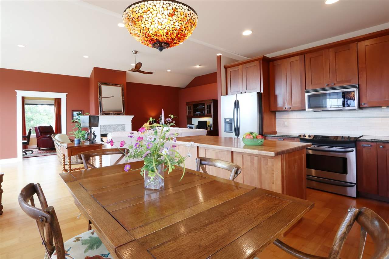 1268 Lower Kimo Drive Kula, HI 96790 - Photo 6 of 30 a kitchen with stainless steel appliances granite countertop a stove top oven a sink dishwasher a dining table and chairs with wooden floor