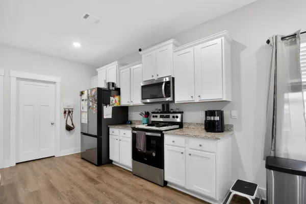 a kitchen with stainless steel appliances granite countertop a refrigerator and a stove top oven