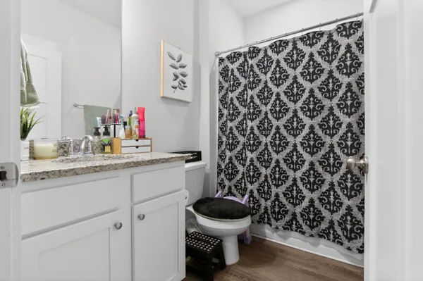 a bathroom with a granite countertop toilet and a sink