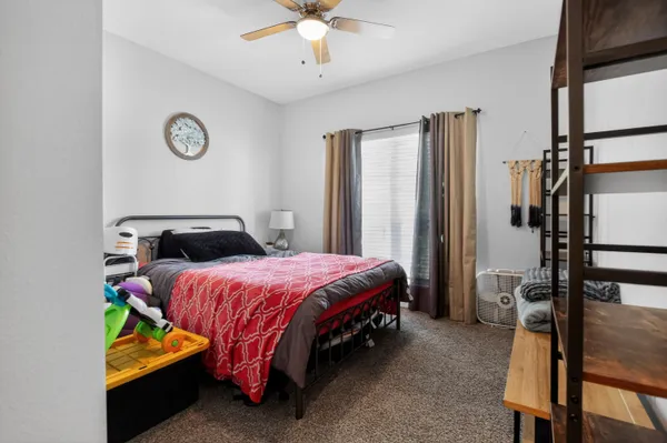 a bedroom with a bed table and a large mirror