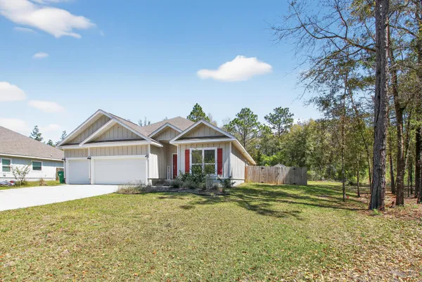 a front view of a house with a yard and trees