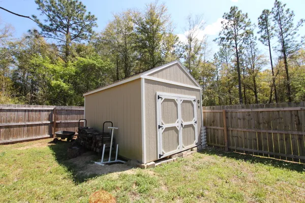 a view of backyard with wooden fence and a large tree