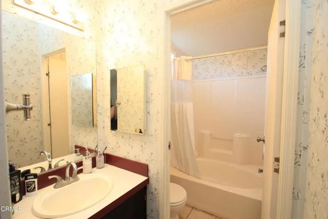 a bathroom with a granite countertop sink a toilet and shower