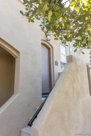 a potted plant is sitting in front of a house with a tree