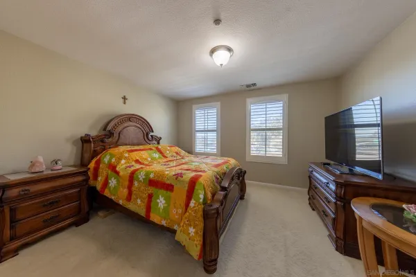 a bed sitting in a bedroom next to a window