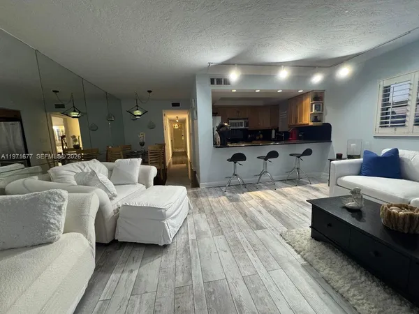 a living room with furniture and a wooden floor