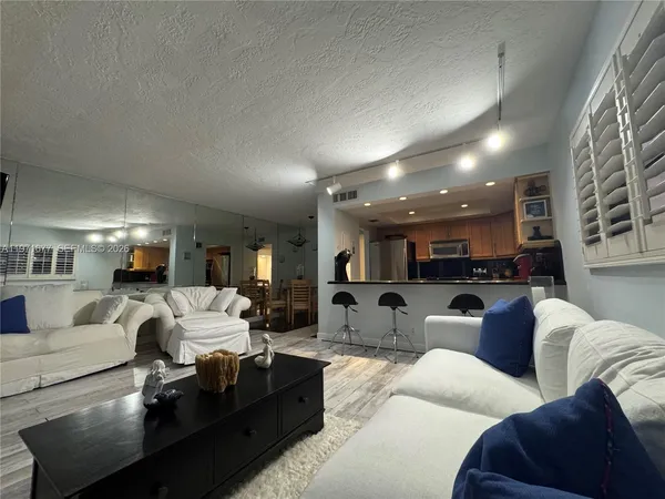 a living room with furniture and a view of kitchen