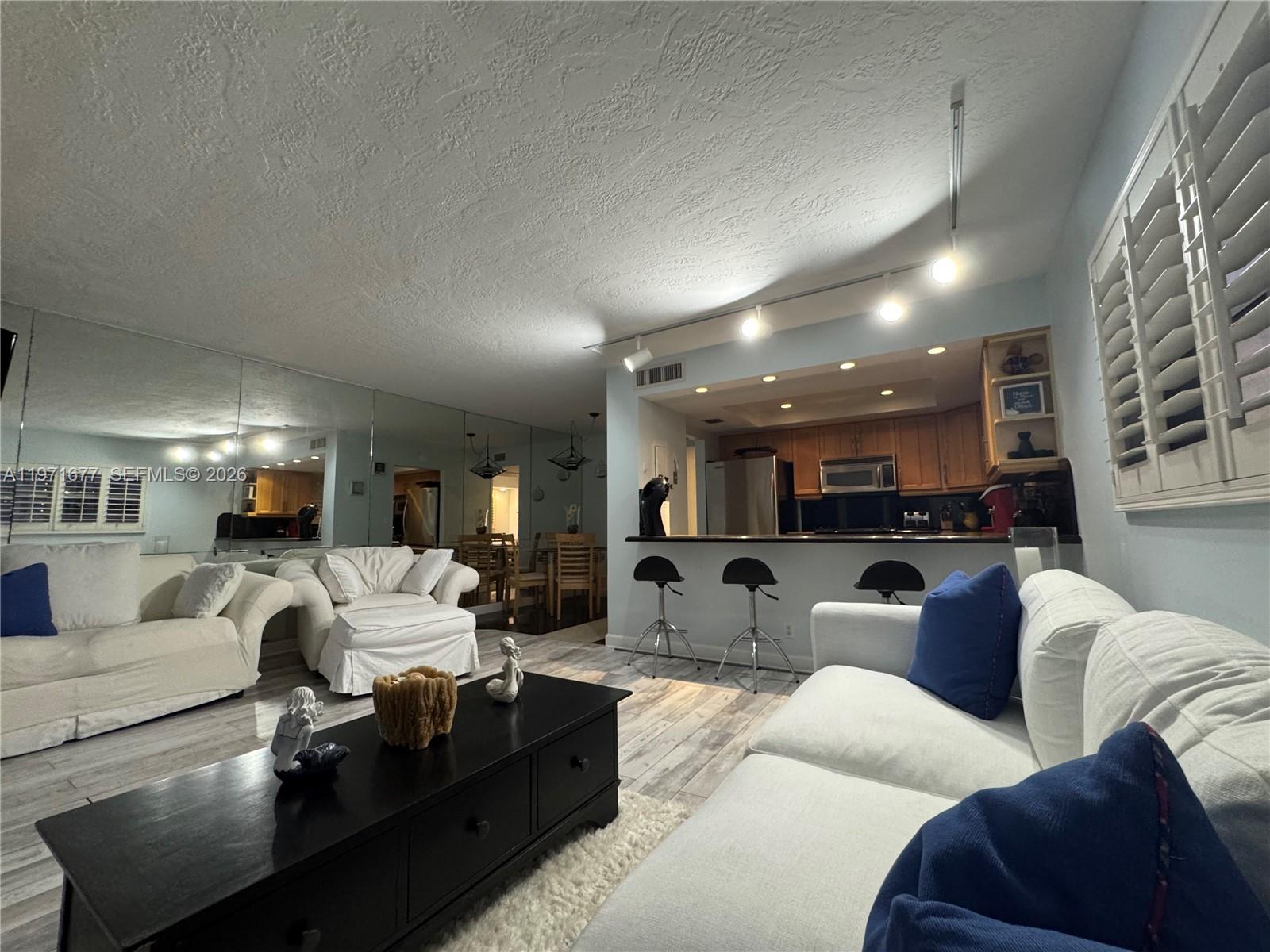 400 North Surf Road, Unit 701 Hollywood, FL 33019 - Photo 6 of 11 a living room with furniture and a view of kitchen