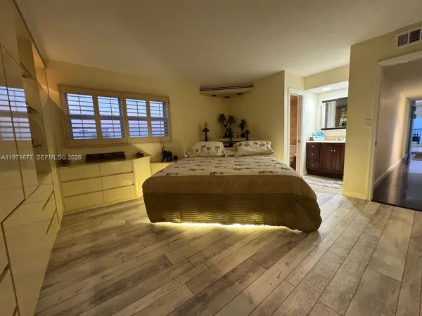 a spacious bedroom with a bed and a dresser