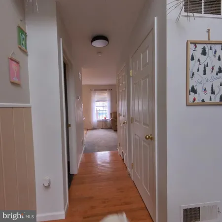 a view of a hallway with a livingroom and a window