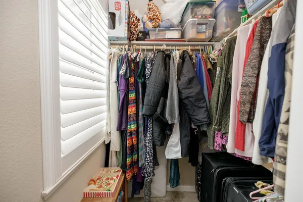 a view of walk in closet with clothes and shoes