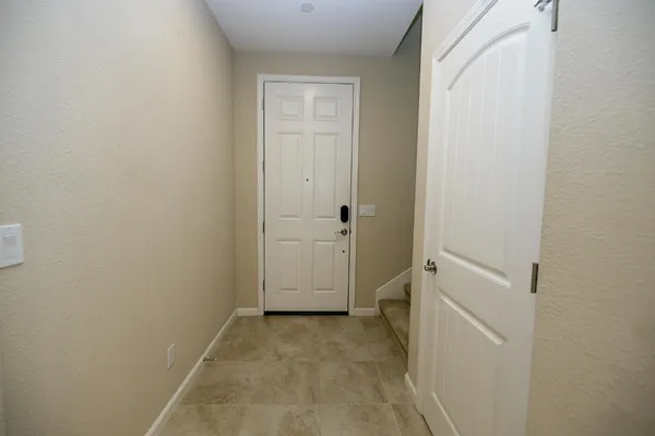 a kitchen with stainless steel appliances granite countertop a refrigerator a sink dishwasher a stove and a dining table with wooden floor