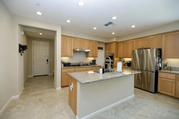 a kitchen with stainless steel appliances granite countertop a sink a stove and a center island