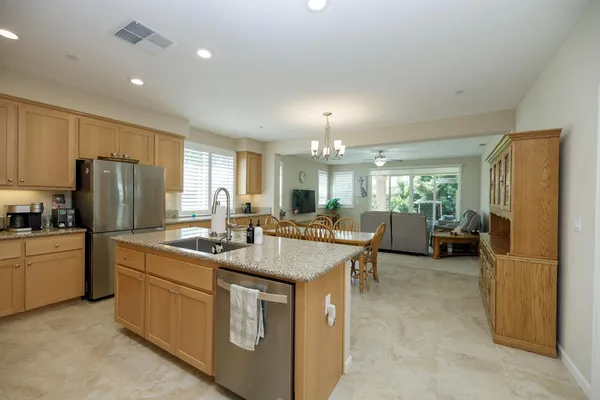 a kitchen with stainless steel appliances granite countertop a refrigerator sink and stove