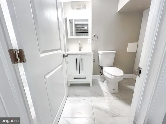 a bathroom with a toilet a sink and a mirror