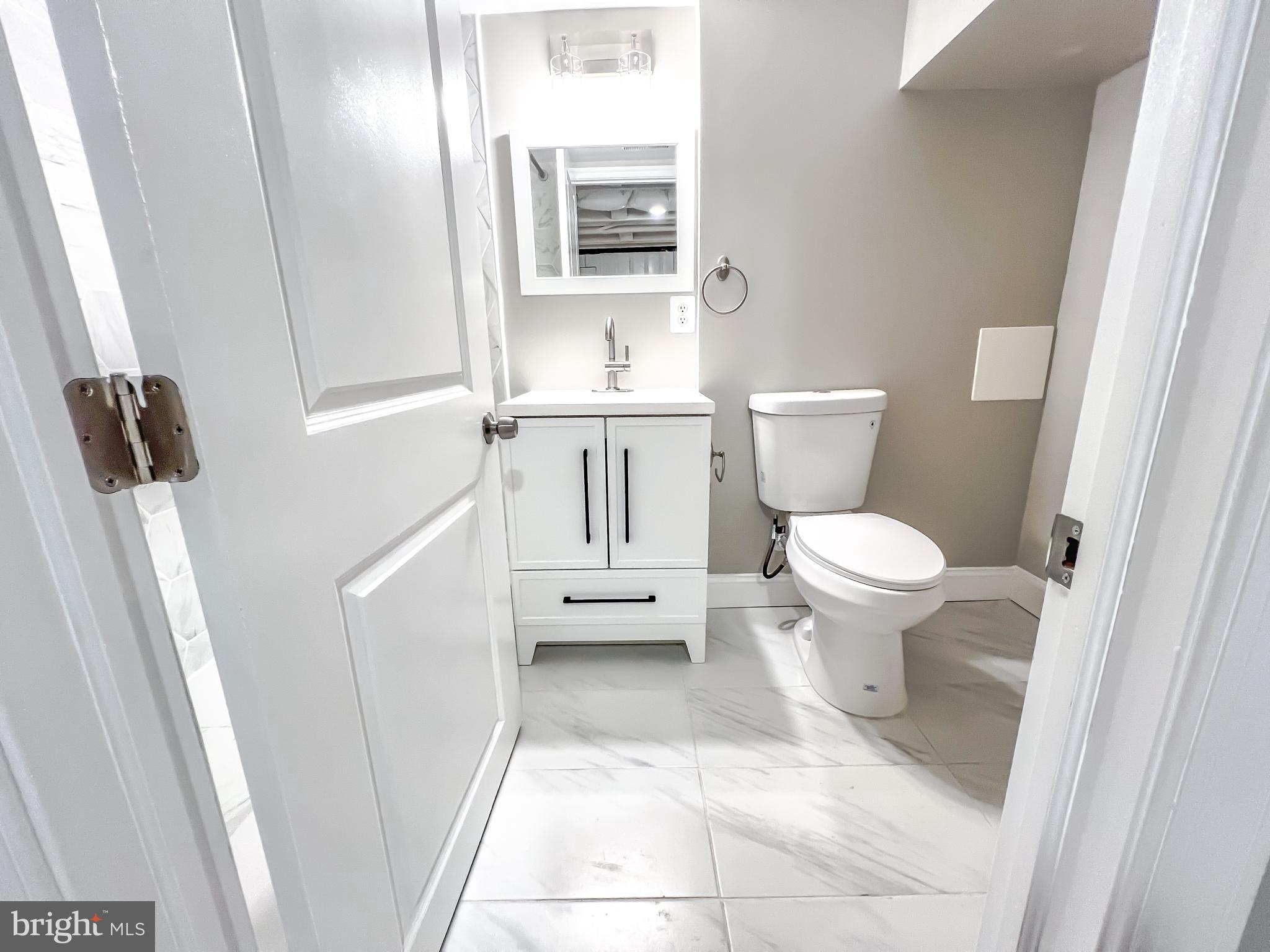 3204 Sequoia Avenue Baltimore, MD 21215 - Photo 12 of 19 a bathroom with a toilet a sink and a mirror