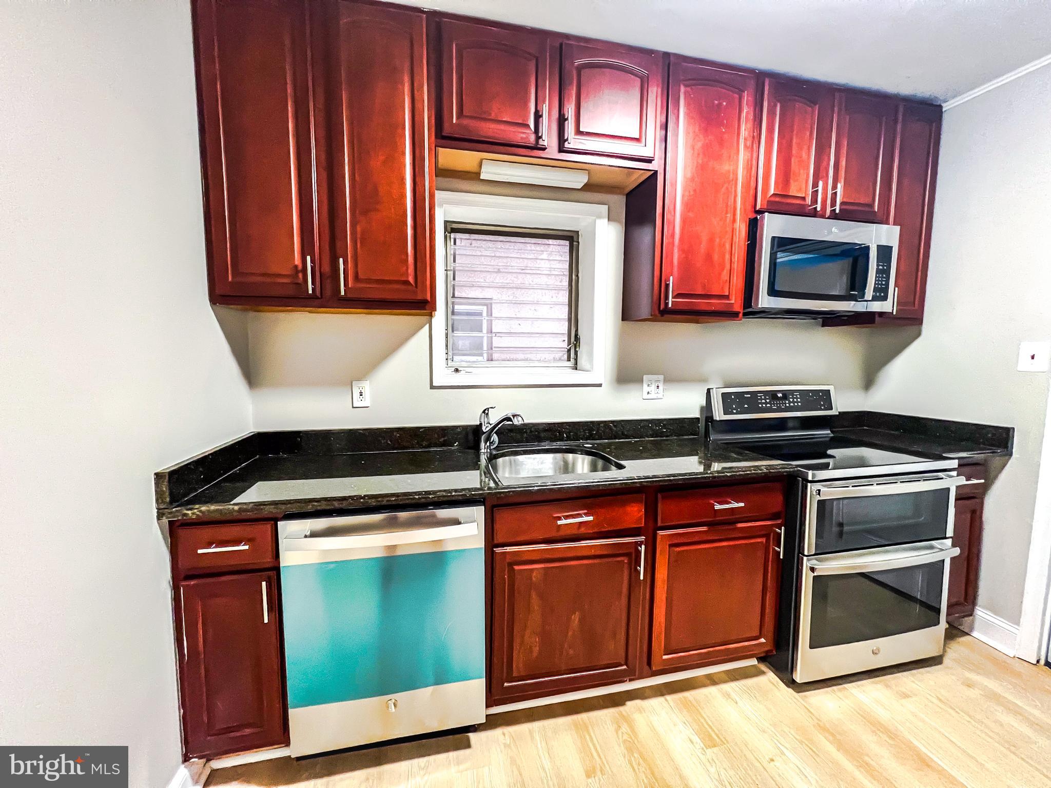 3204 Sequoia Avenue Baltimore, MD 21215 - Photo 16 of 19 a kitchen with granite countertop a stove top oven microwave and cabinets