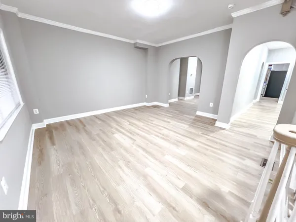 a view of empty room with wooden floor
