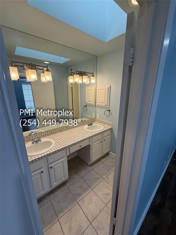 18240 Midway Road, Unit 606 Dallas, TX 75287 - Photo 18 of 25 a bathroom with a double vanity sink a mirror and a bathtub